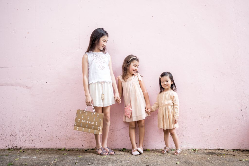 Three girls posing against the wall